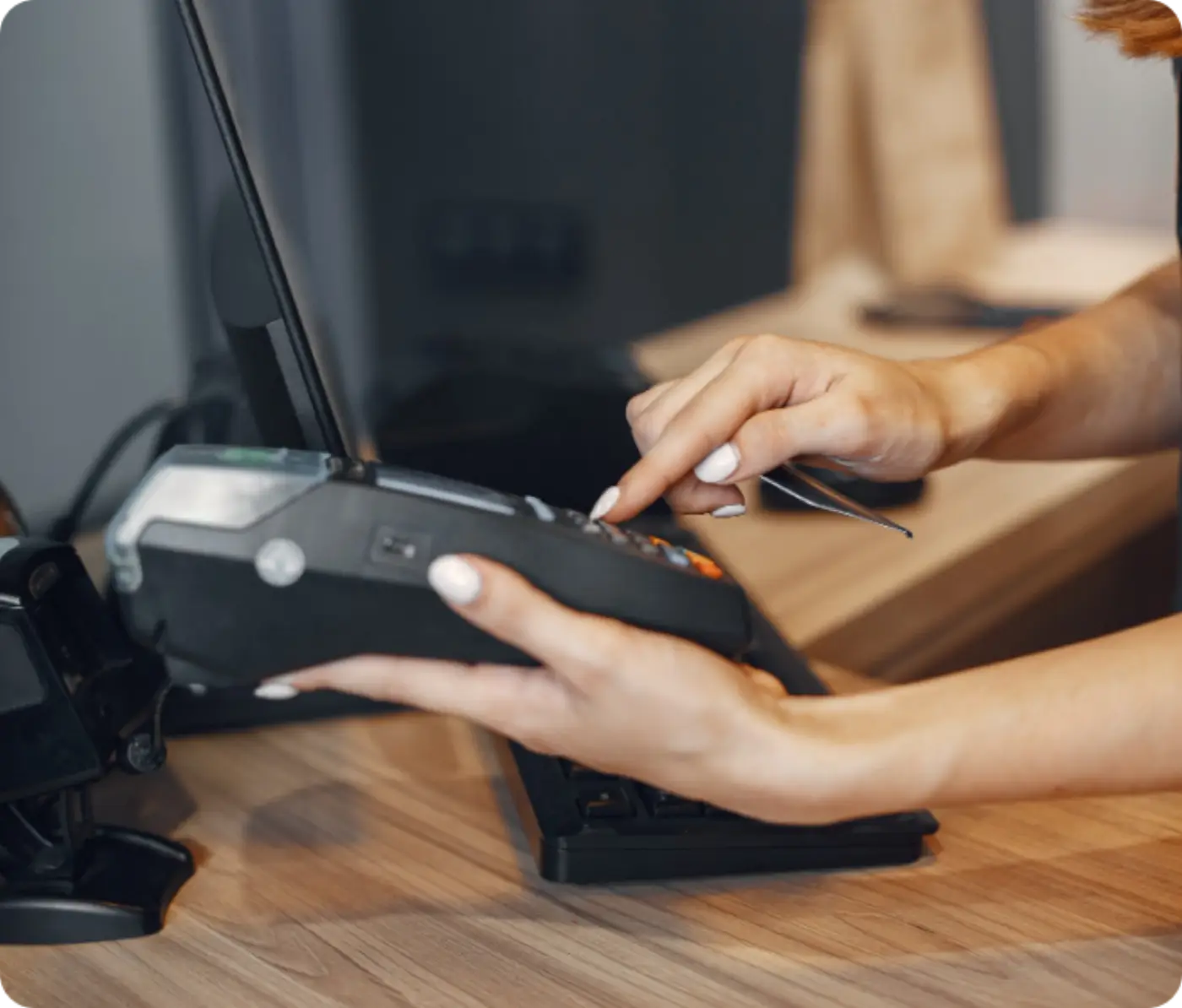 Hands using a card terminal at a shop counter